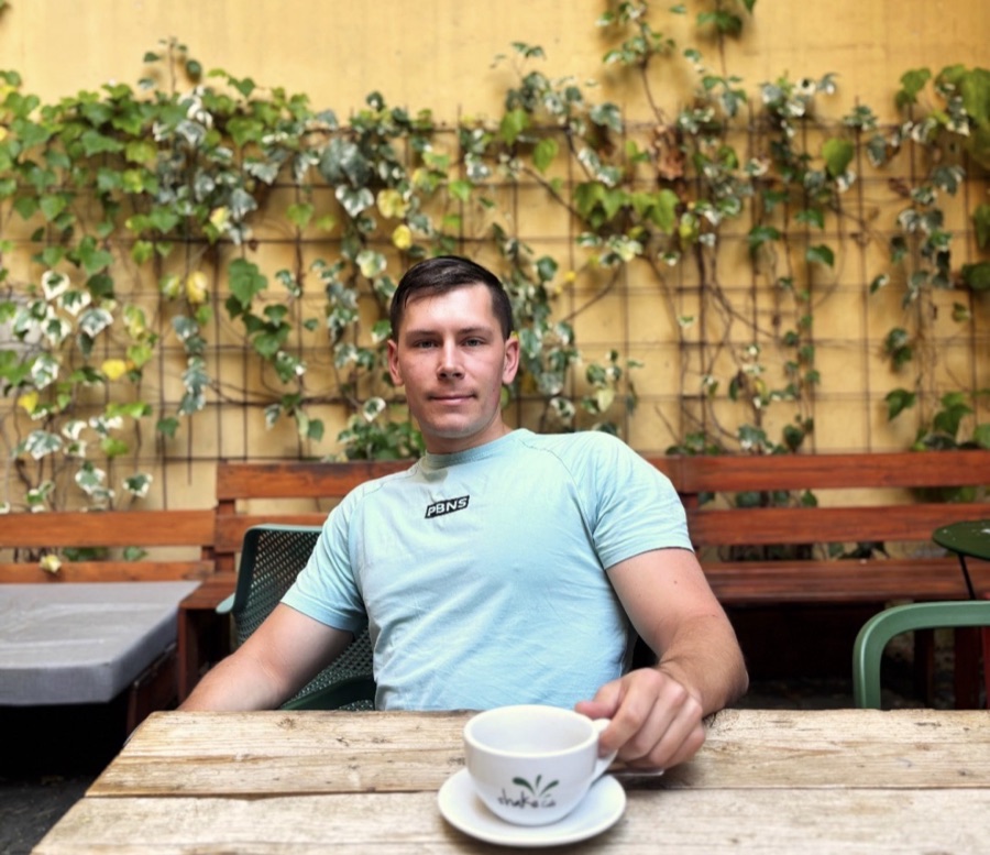 Jonah Kubath, founder of SimpleFinances, sitting at an outdoor cafe table